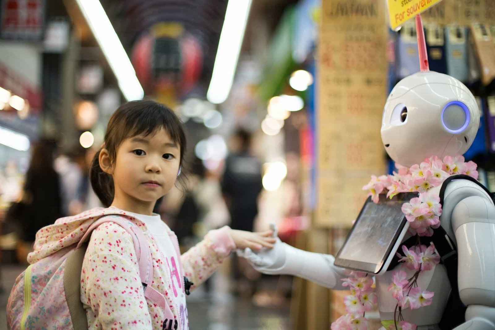 A japanese girls holds hands with a robot