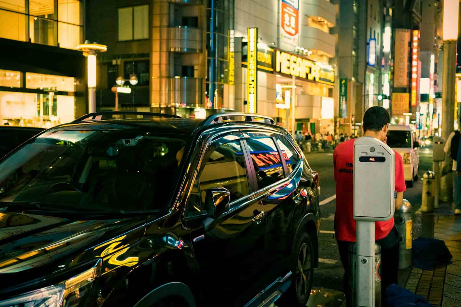 A man standing next to an EV in Japan.