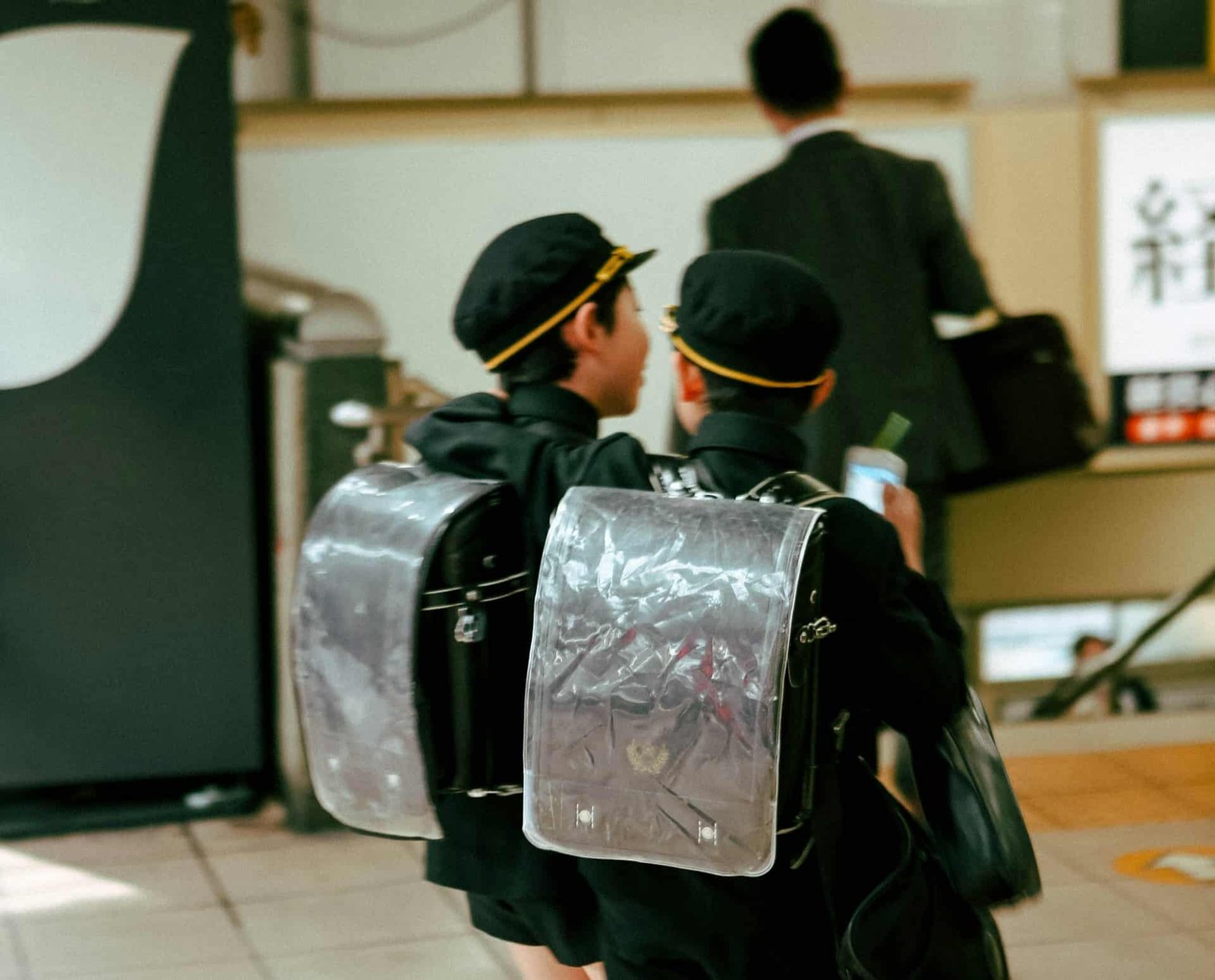 Two schoolboys walking through a Japanese train station.