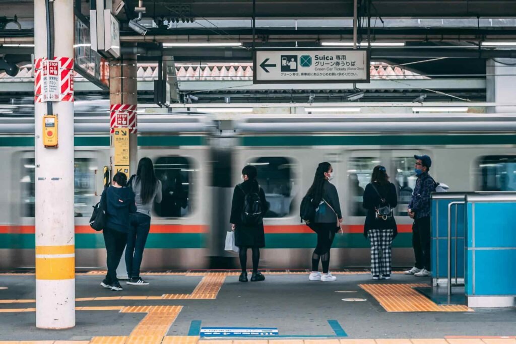 Japanese train station where a train is leaving the platform