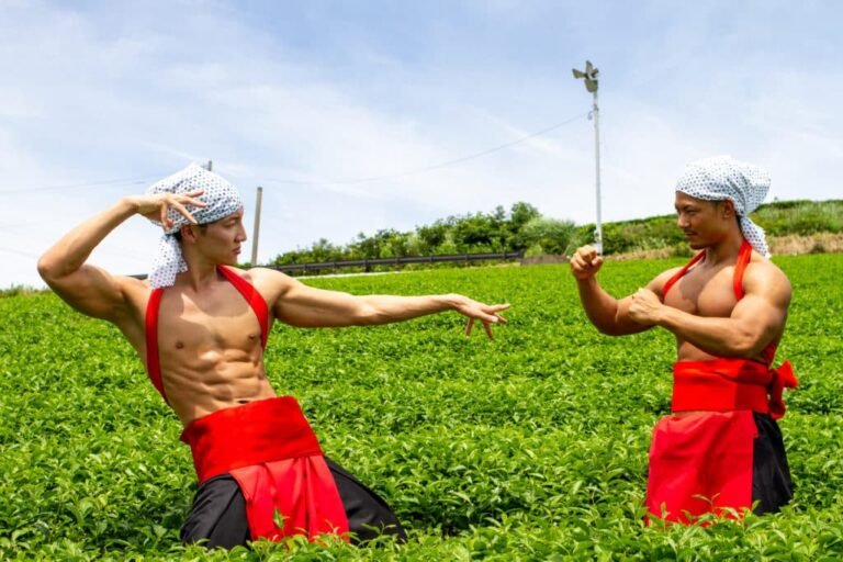 Two japaense men with bulging muscles posing in a tea field