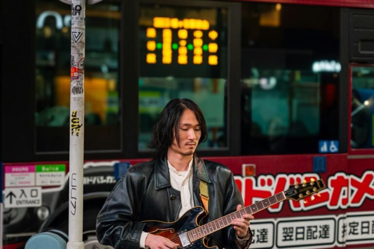 A japanese man playing guitar music on the street