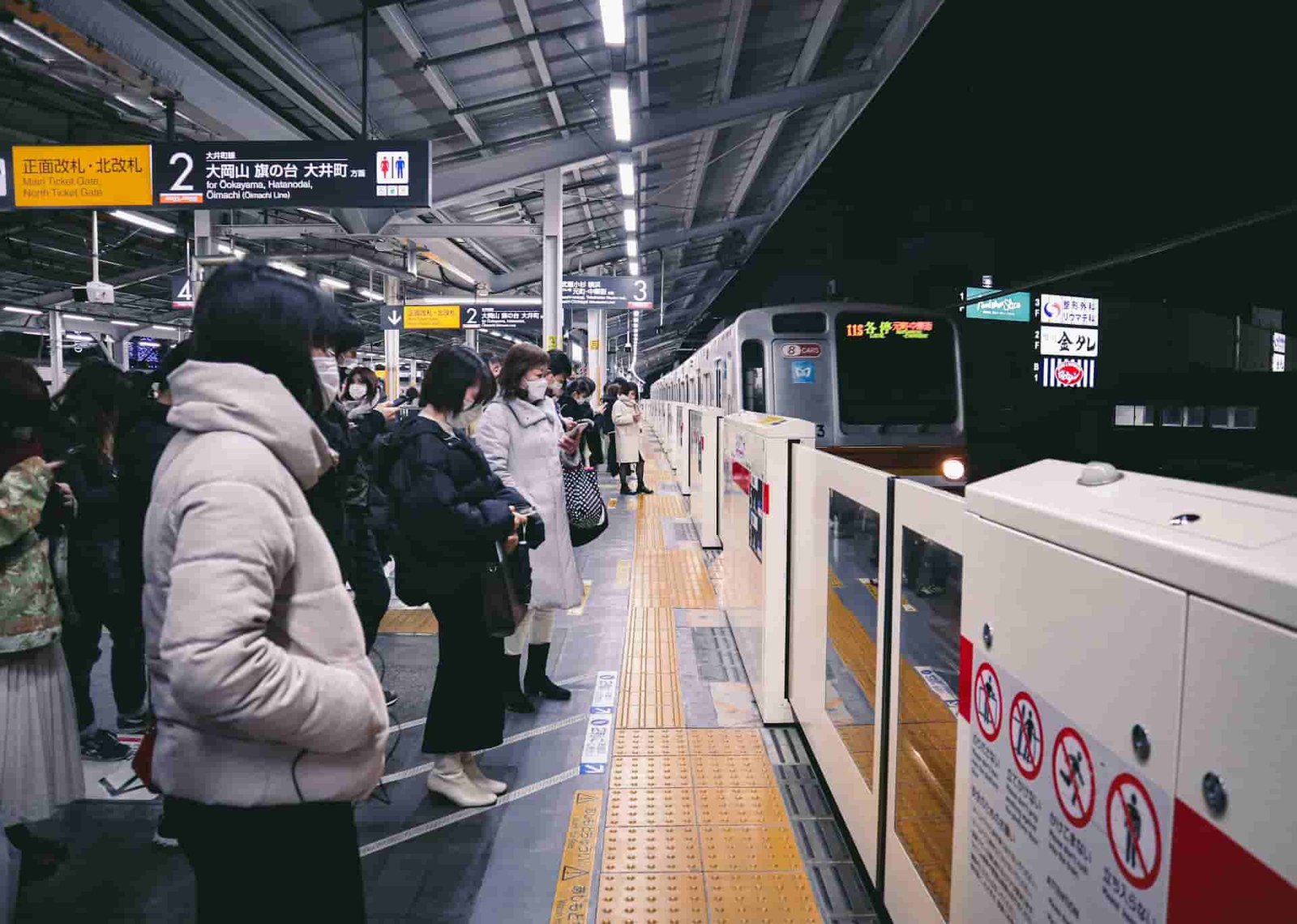 Peolpe waiting for a train at a station in Japan