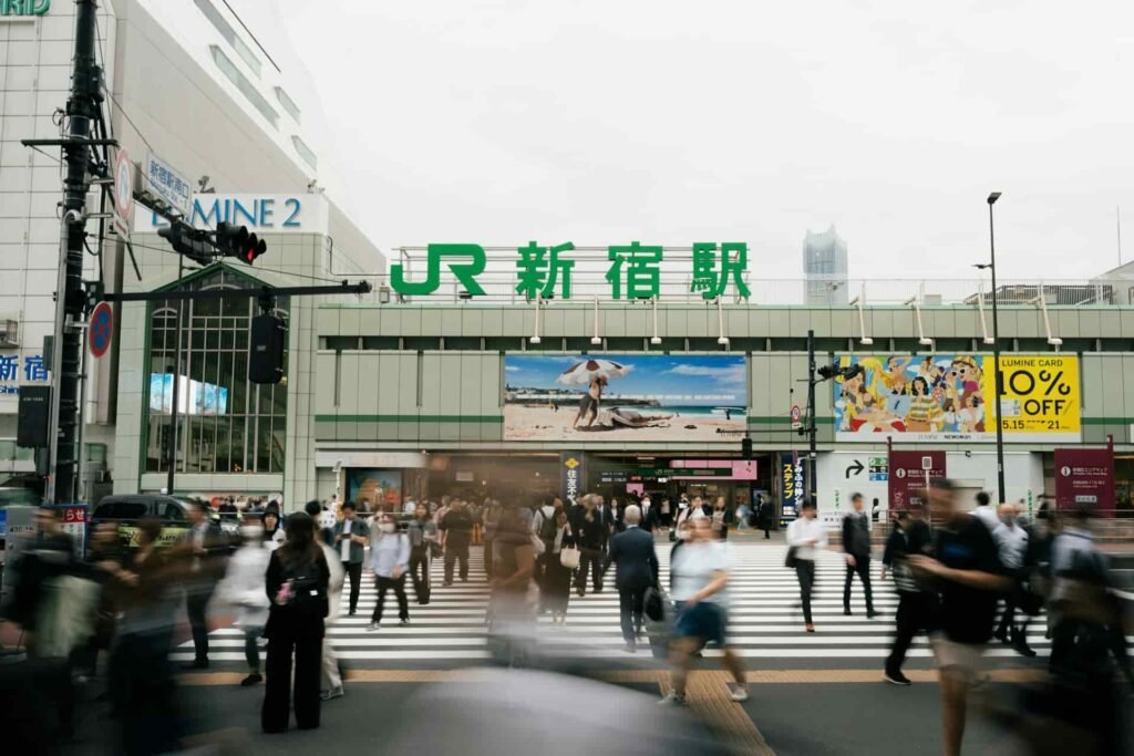 Crowds pass outside of Shinjuku Train Station.